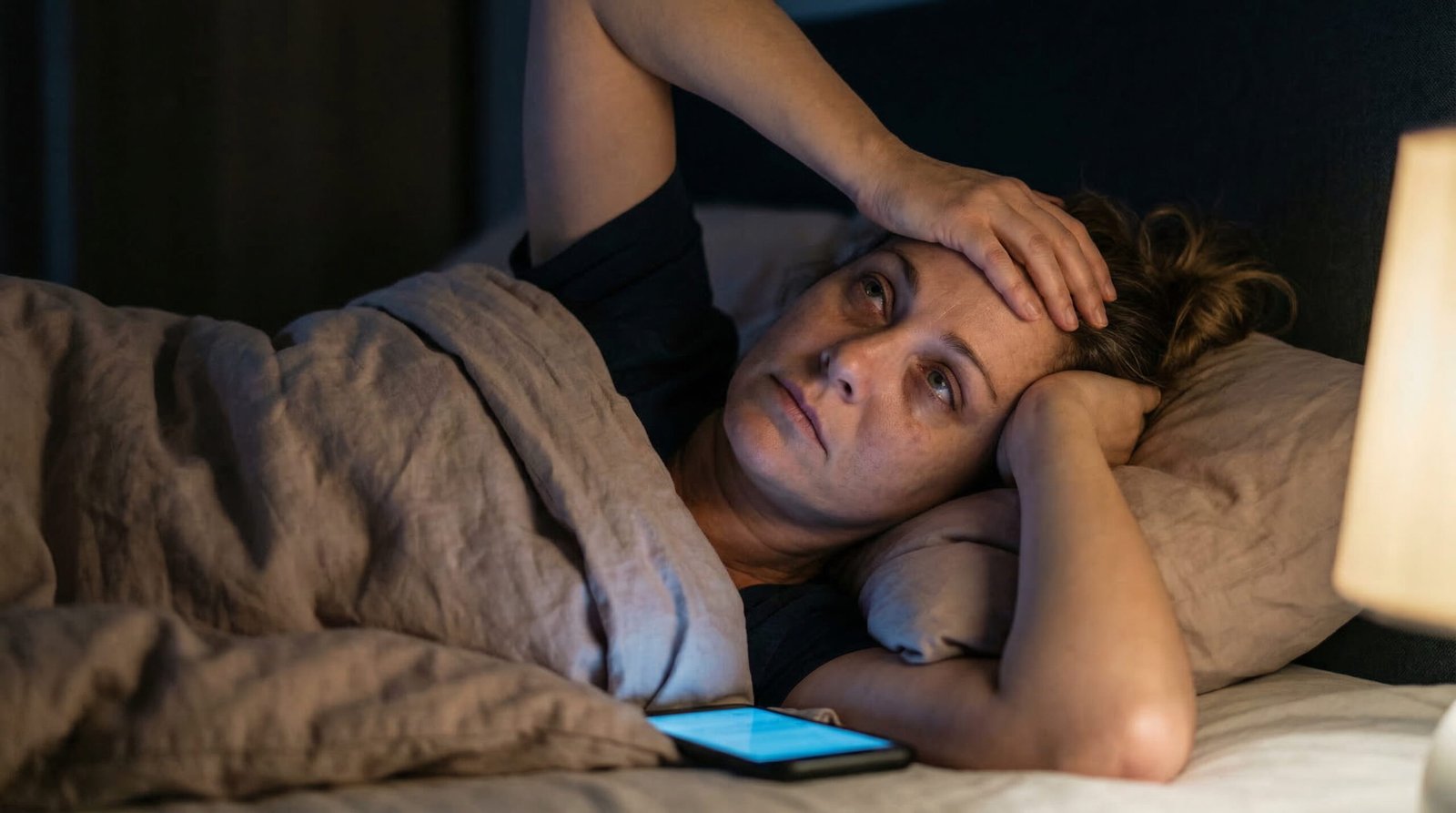 Woman watching the clock at 3am unable to fall asleep — replace with nighttime insomnia stock photo